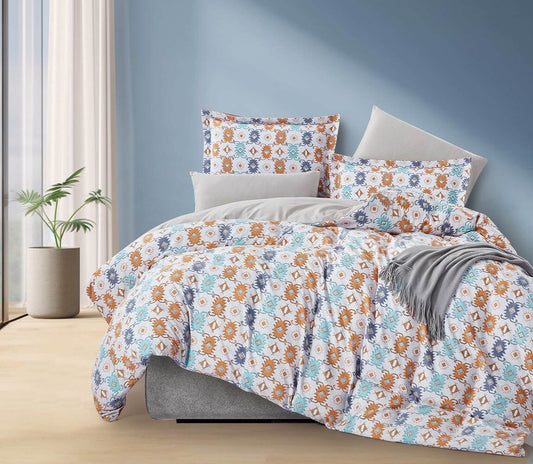 A bedding set with a floral pattern, featuring a duvet cover and pillowcases, displayed on a bed with a blue wall in the background.
