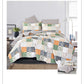 Patchwork quilt set on a bed in a bedroom setting