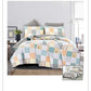 Patchwork quilt set on a bed in a bedroom setting
