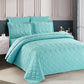 Turquoise quilt set on a bed in a bedroom setting
