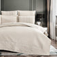 Beige quilted coverlet set on a bed in a bedroom setting.
