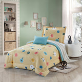 A bedding set with a floral petal print, displayed in a bedroom setting, including a comforter, pillows, and a bedsheet.