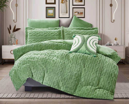 An emerald green quilted flannel comforter set on a bed, with additional pillows and a comforter draped over the edge of the bed, presented in a room setting.