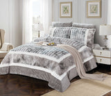 A king-size comforter set with a colorblock flannel design in gray and white, displayed on a bed with additional pillows and a duvet cover.