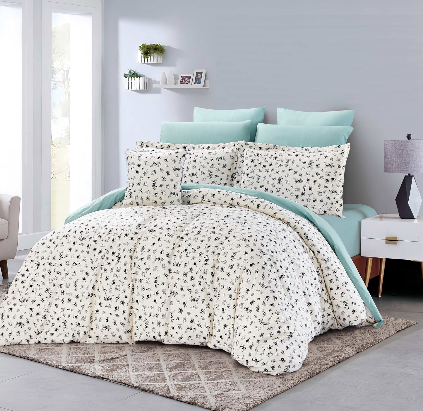 Bed with floral comforter and light blue pillows in a bedroom setting.