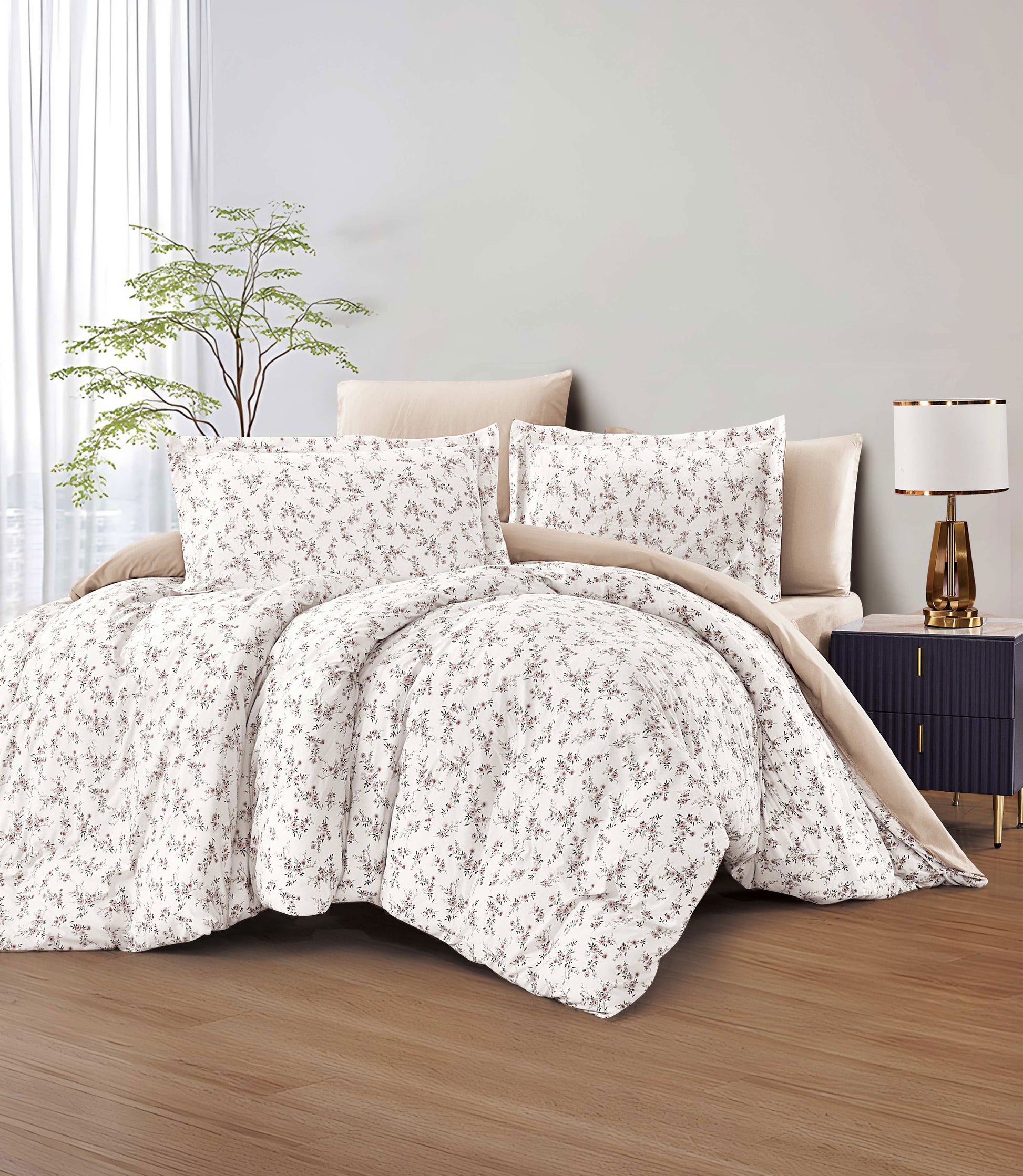 Floral comforter set on a bed in a bedroom with a lamp and plant.