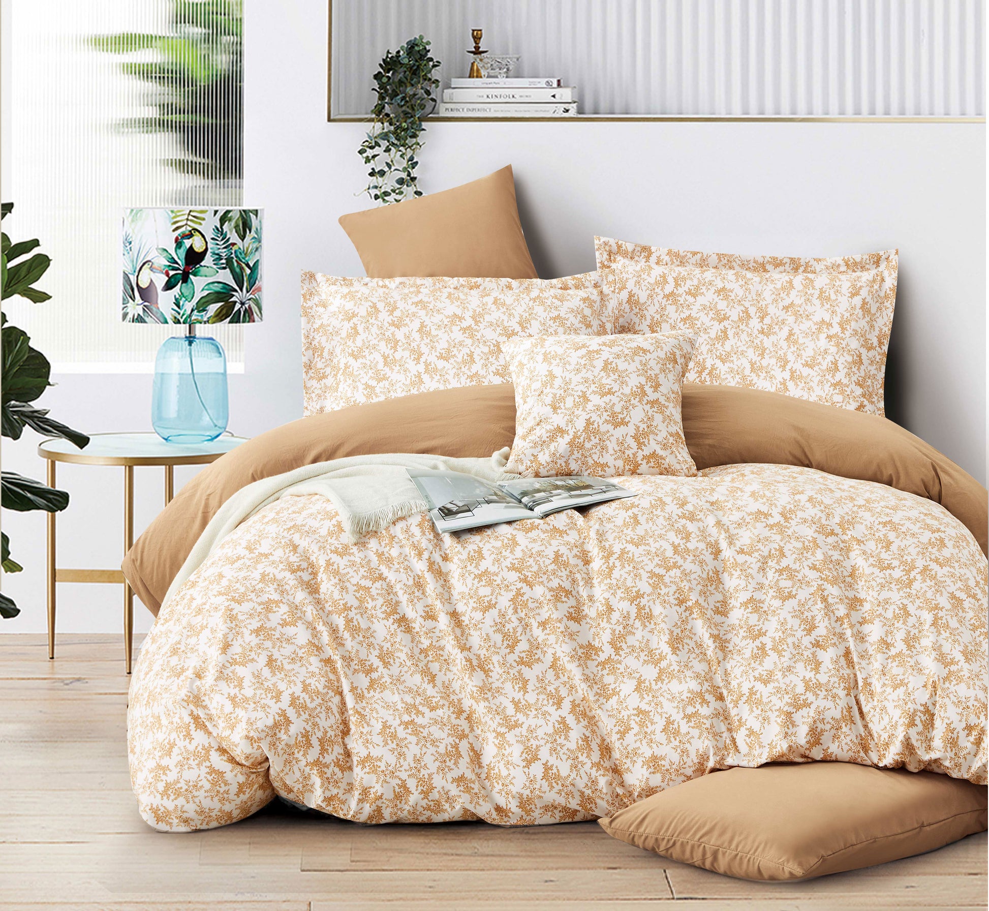 Floral bedding set on a bed in a bedroom with plants and decor.