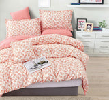 Floral comforter set on a bed in a bedroom with a dresser and decor items.