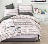 Bed with striped bedding and decorative pillows in a bedroom setting.