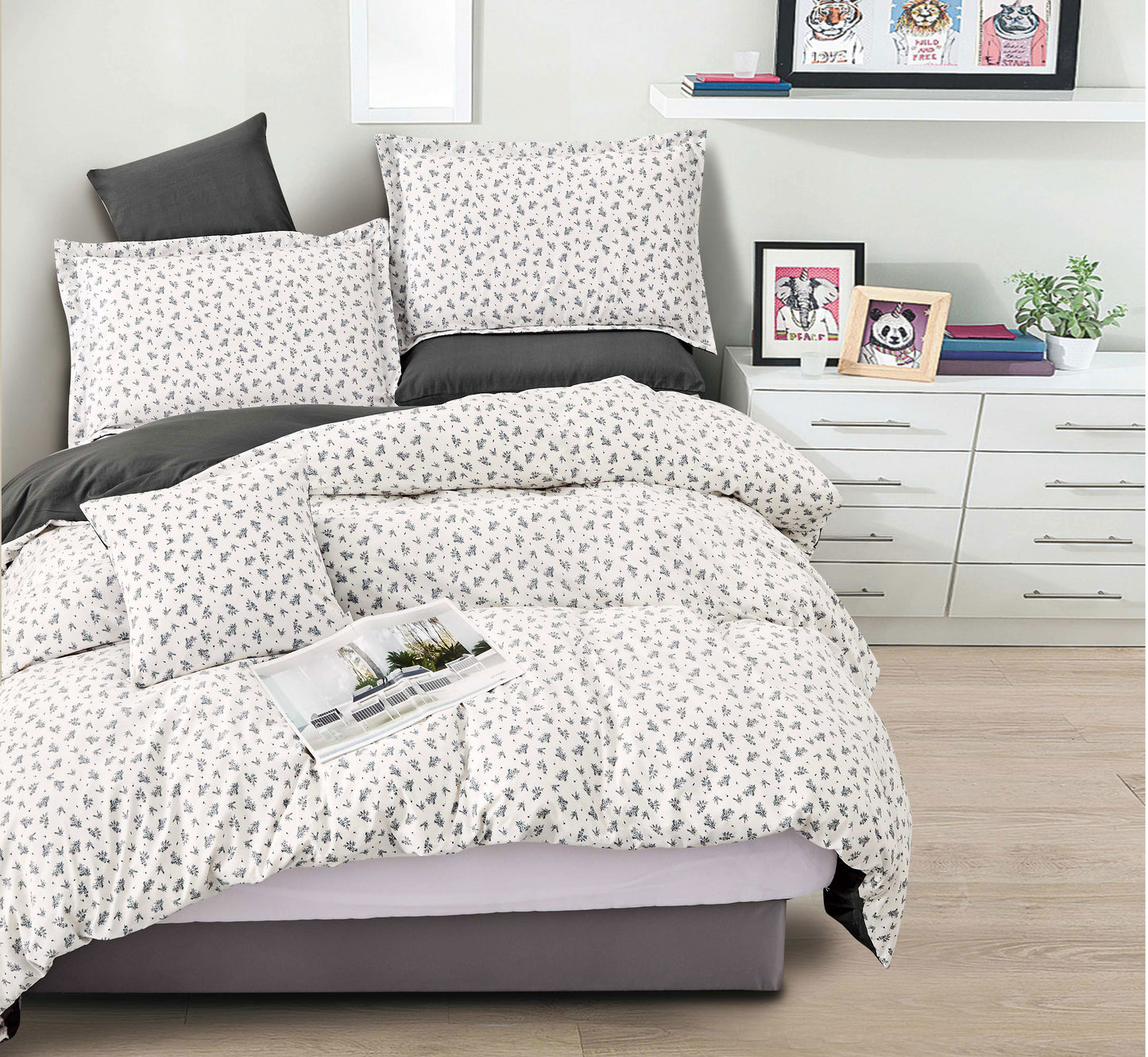 Bedding set with white and gray pattern on a bed in a bedroom setting.