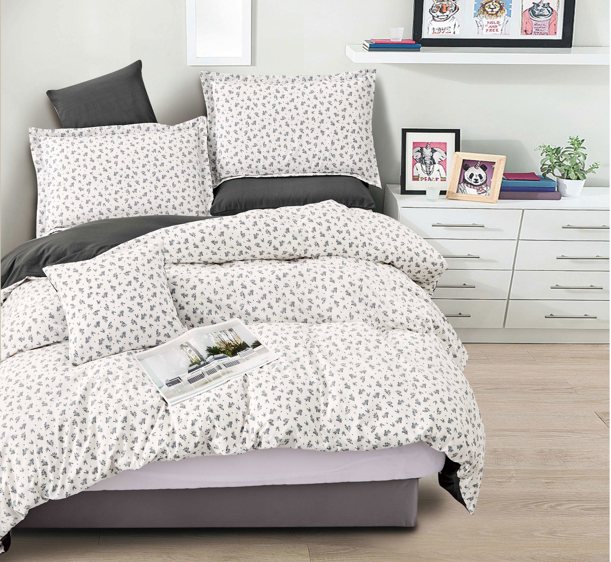 Bedding set with white and gray pattern on a bed in a bedroom setting.