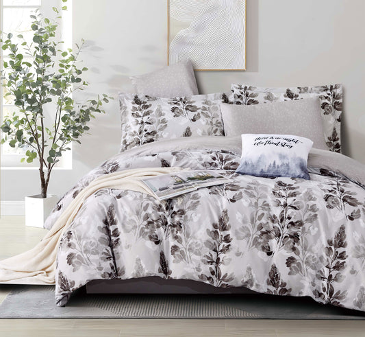 Floral bedding set on a bed in a bedroom with a plant and artwork.