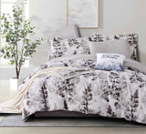 Floral bedding set on a bed in a bedroom with a plant and artwork.