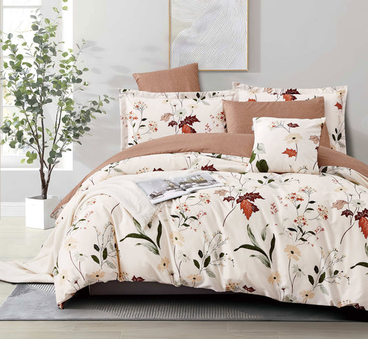 Floral bedding set on a bed with a plant and artwork in the background