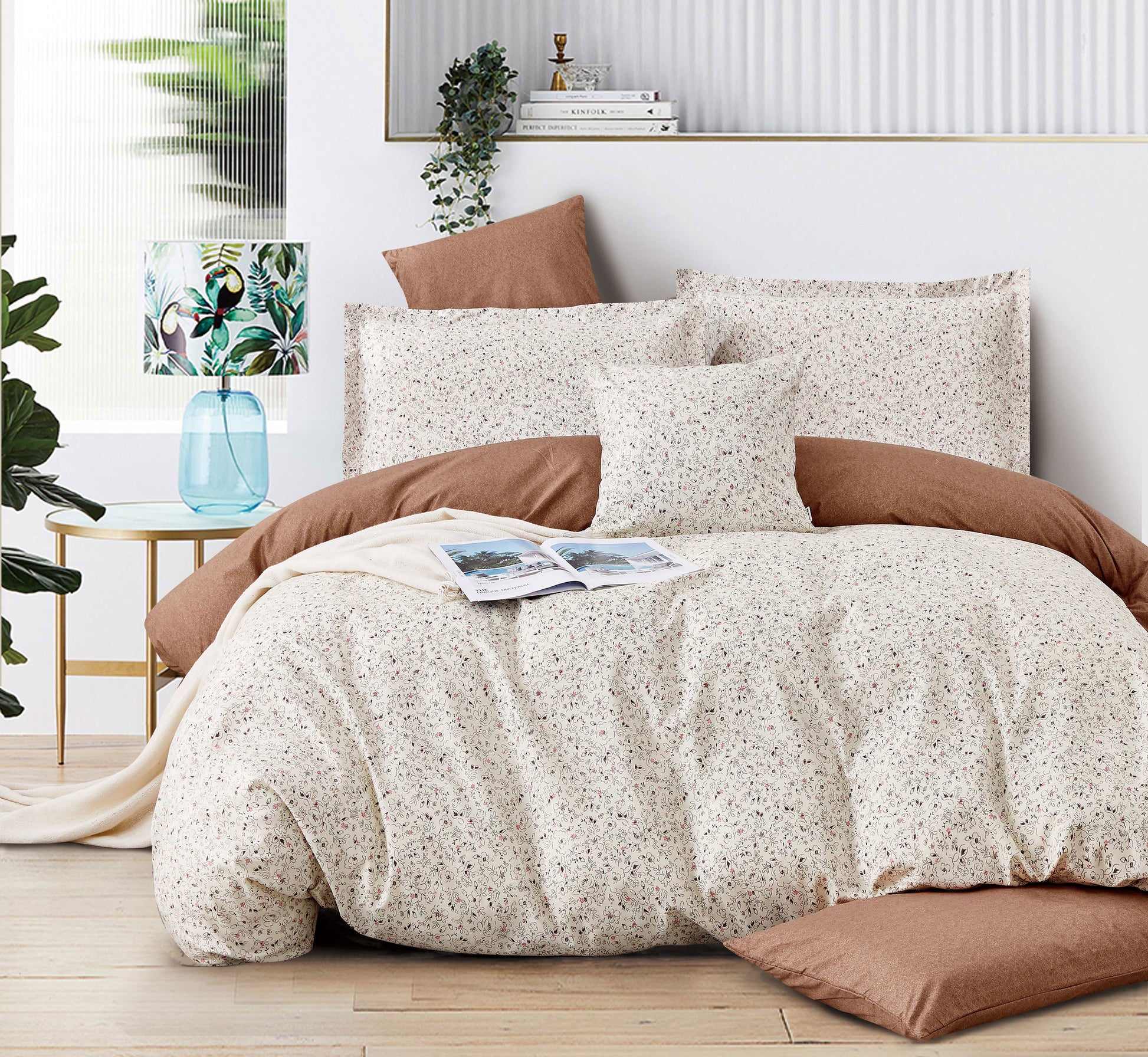 Neatly made bed with beige and brown bedding in a well-lit bedroom.