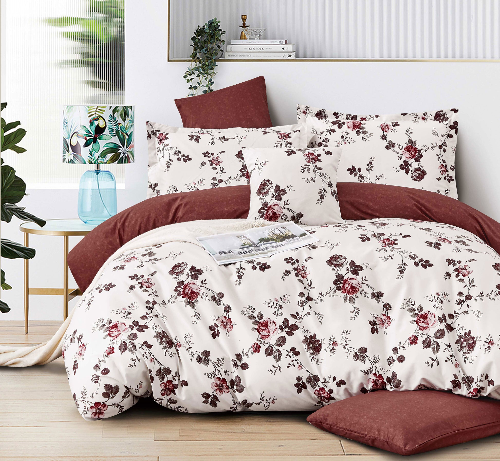 Floral bedding set on a bed with a red headboard in a bedroom setting.