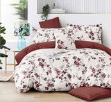 Floral bedding set on a bed with a red headboard in a bedroom setting.