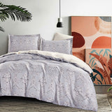 Gray floral-patterned comforter set on a bed with abstract art in the background