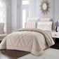 Beige quilted comforter set on a bed in a stylish bedroom with decorative pillows and a mirror.