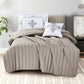 Quilted brown comforter set on a bed with decorative pillows in a bedroom setting.